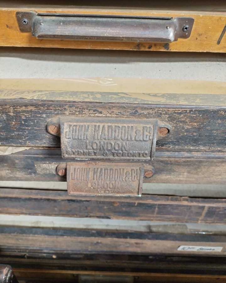 A close view of the brass label on an old wooden type drawer